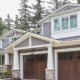 Traditional house with gray siding, white frame windows and natural stone.