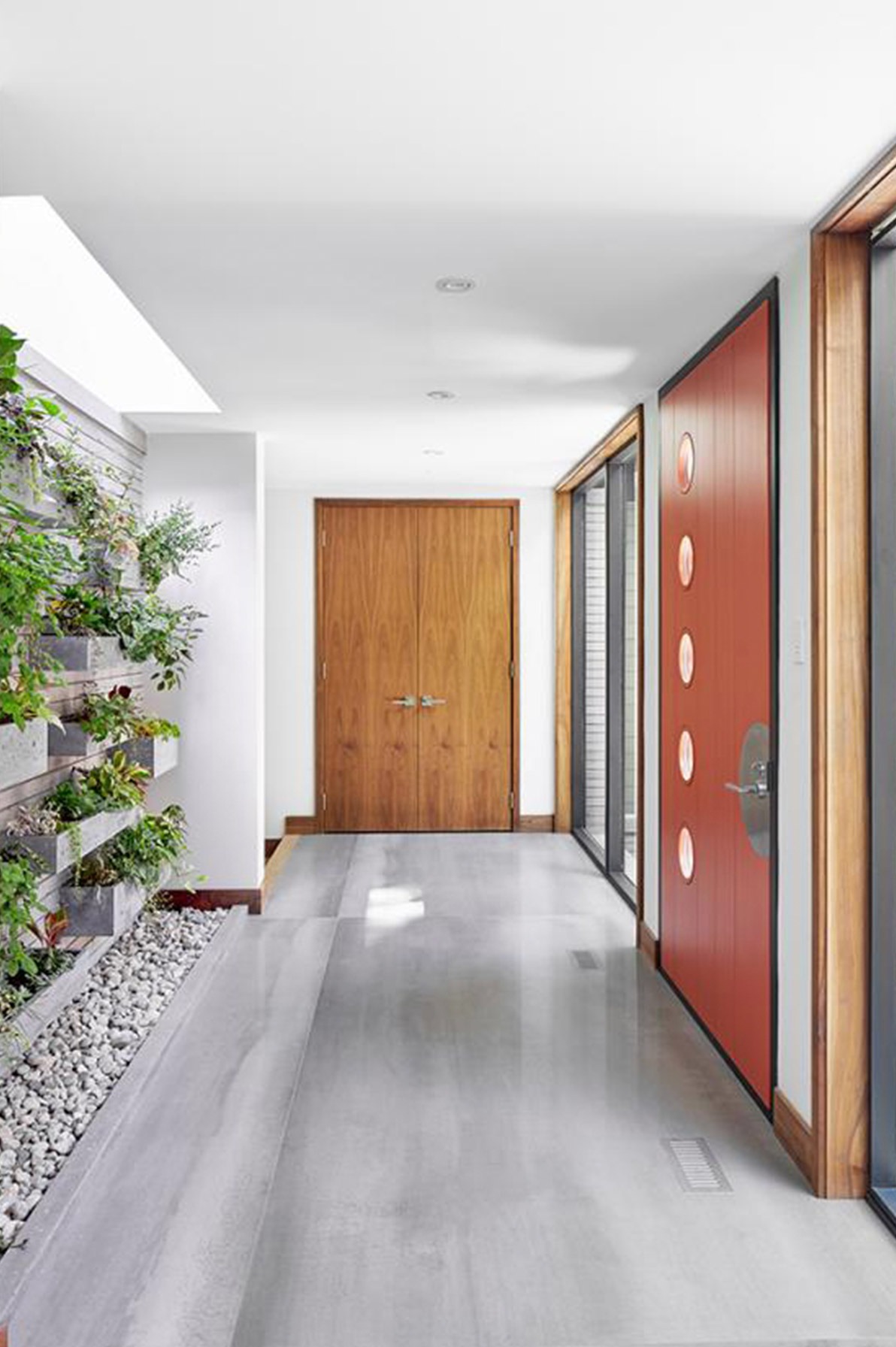 Modern house with orange door, black frame windows and gray tile.