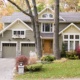 Mississauga traditional house with green siding, stone skirt and white trim.