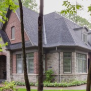 Misissauga house with natural stone, red brick and grey trim.