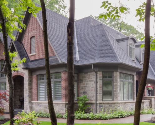 Misissauga house with natural stone, red brick and grey trim.