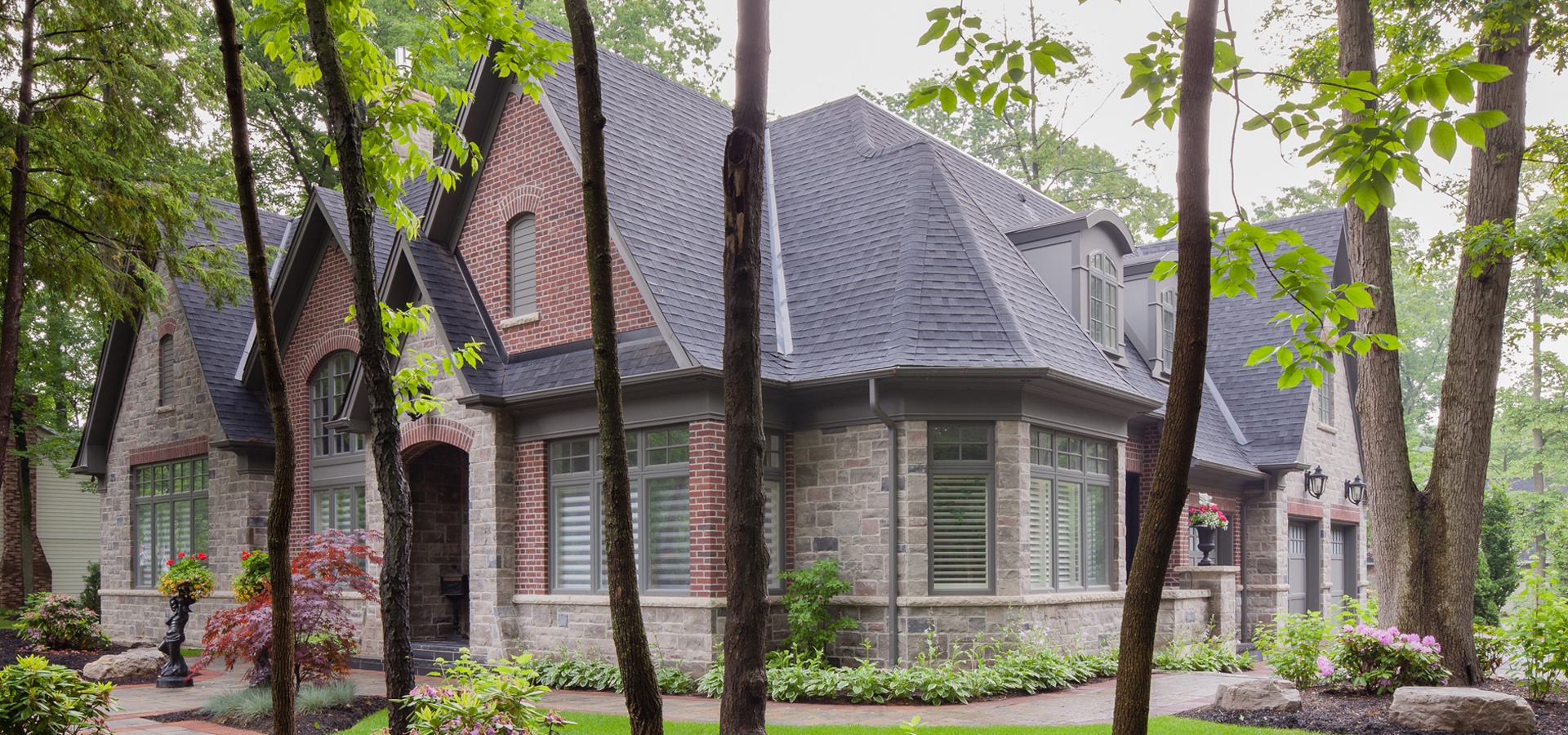 Misissauga house with natural stone, red brick and grey trim.