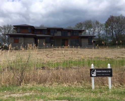 Michigan modern house with natural stone, floating roof and wood siding.