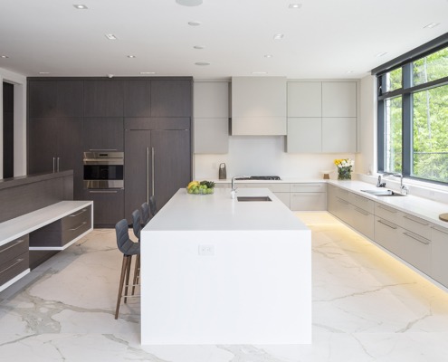 Kitchen with black frame windows, gray cabinets and breakfast bar.