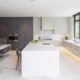 Kitchen with black frame windows, gray cabinets and breakfast bar.