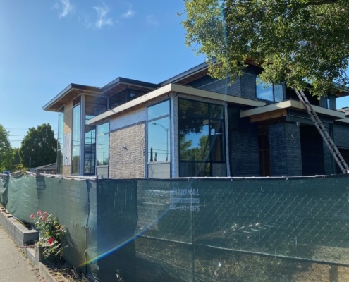 US home with flat roof, corner windows and roof overhang.