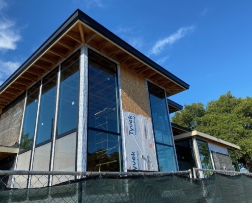 California home with floor to ceiling windows, roof overhang and flat roof.