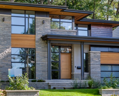 Toronto house with black frame windows, wood soffit and stone planter.