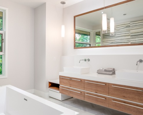 Bathroom with floating vanity, double sink and white frame window.