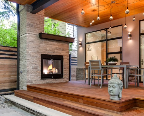 Modern home with stone fireplace, wood deck and natural stone.