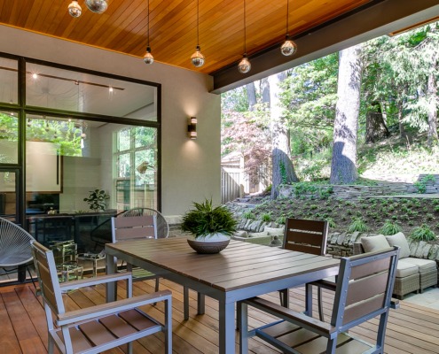 Home wood deck with wood soffit, steel beam and black frame window.