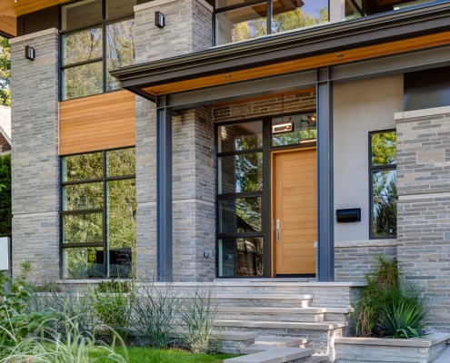 Modern house with natural stone, wood siding and steel columns.