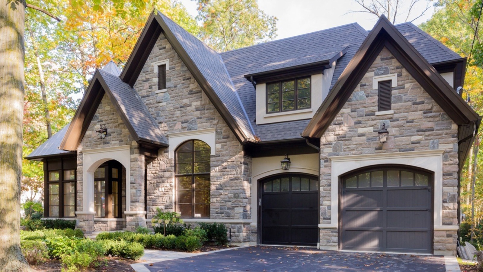 Mississauga house with arched window, dark garage door and gables.