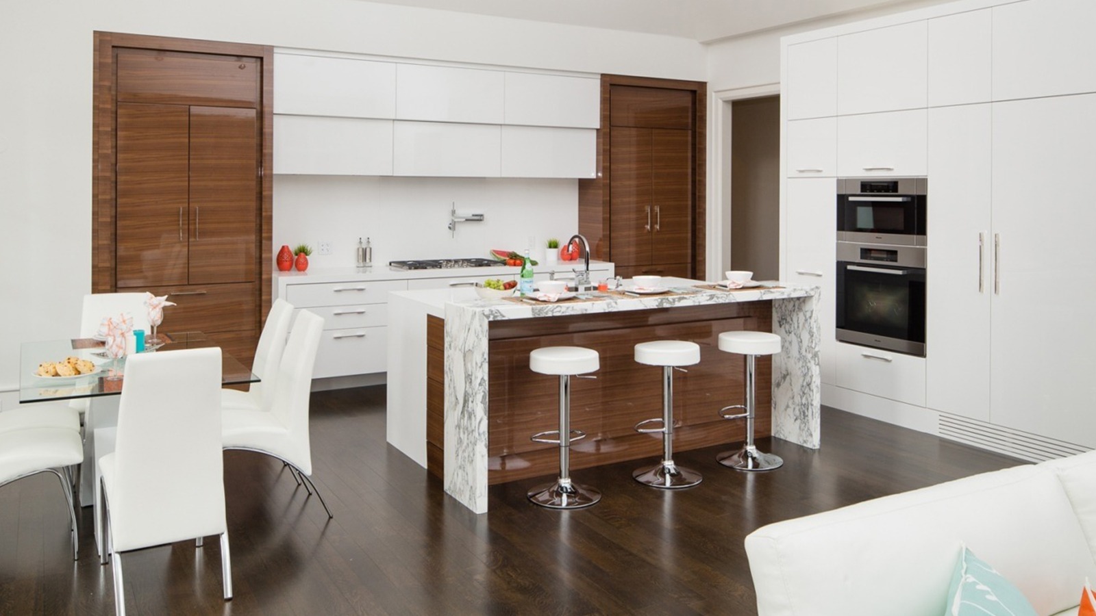 Modern kitchen with white countertop, wood island and hardwood floor.