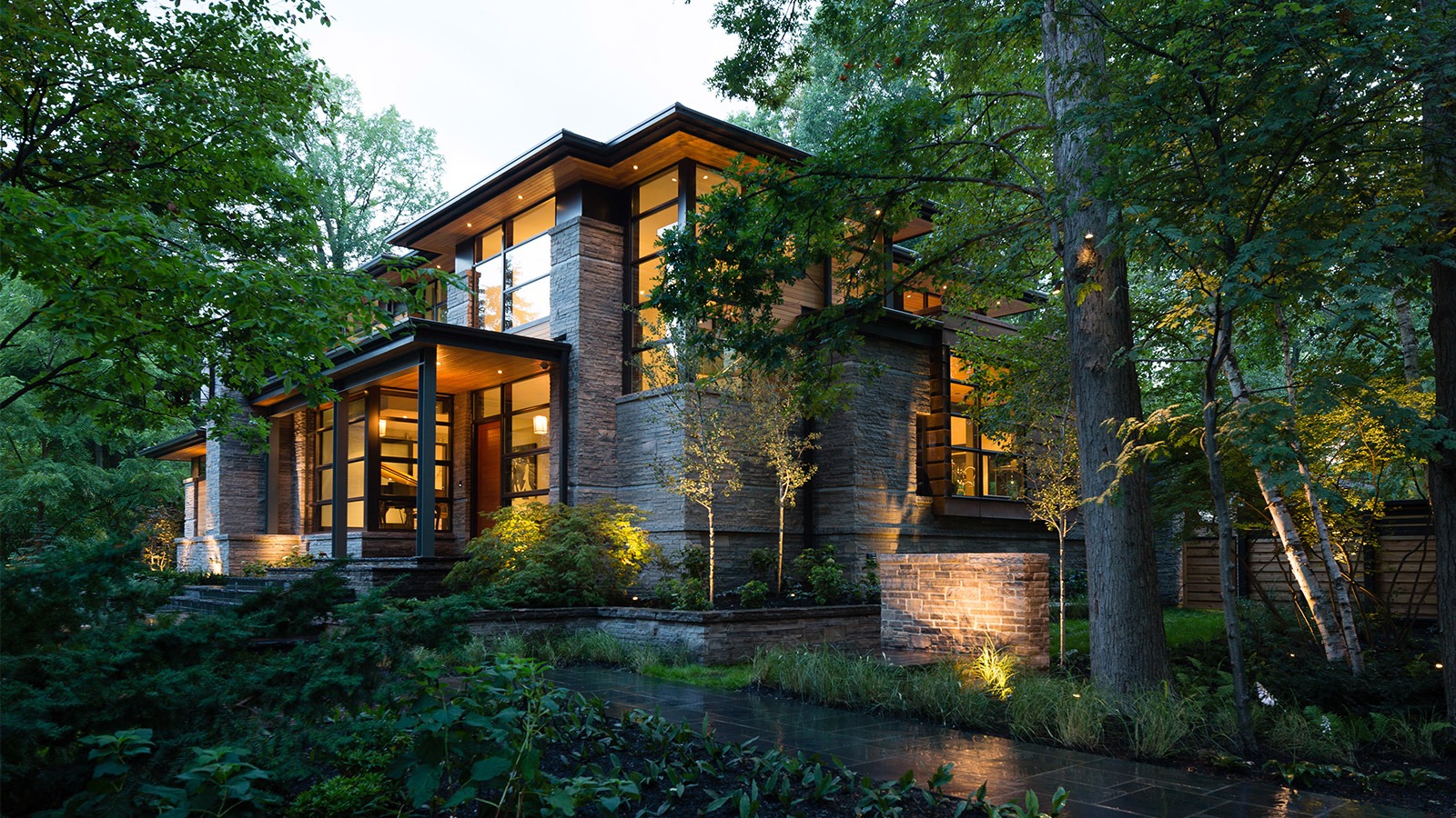 Natural modern home with wood soffit, natural stone and black trim.