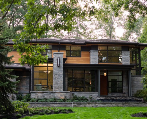 Contemporary house with stone siding, steel columns and wood shingles.