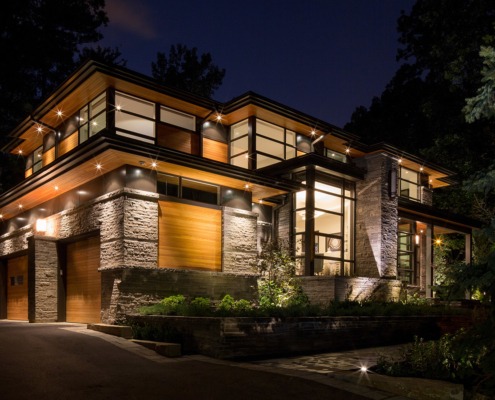 Natural modern home with wood garage door, wood soffit and floating roof.