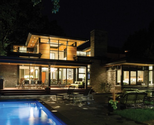 Contemporary home with unground pool, floor to ceiling glass and large patio.