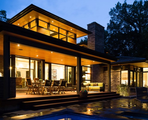 Home backyard with flagstone patio, covered deck and natural stone.