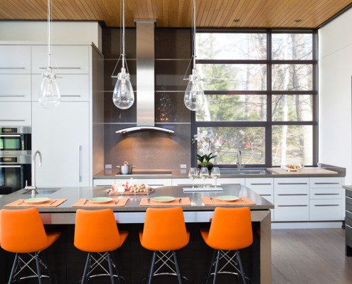 Contemporary kitchen with dark cabinetry, black frame windows and breakfast bar.