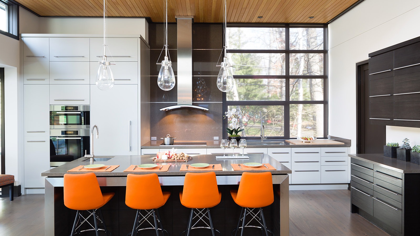 Contemporary kitchen with dark cabinetry, black frame windows and breakfast bar.