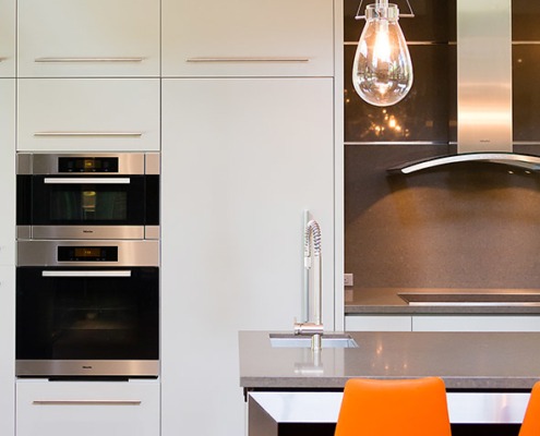 Kitchen with caesarstone countertop, double oven and stainless steel trim.