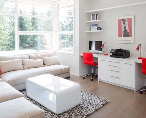 Den with corner window, white baseboard and beige trim.