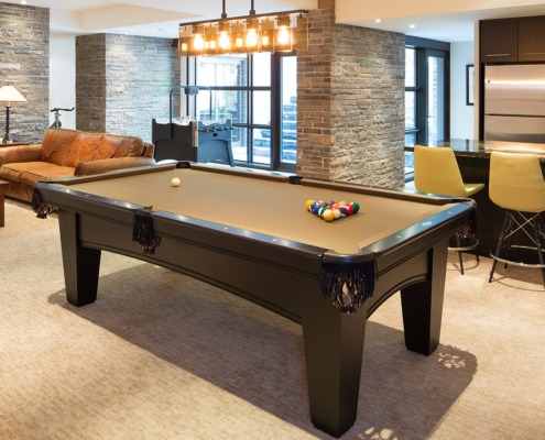 Rec room with pool table, home bar and exposed stone.