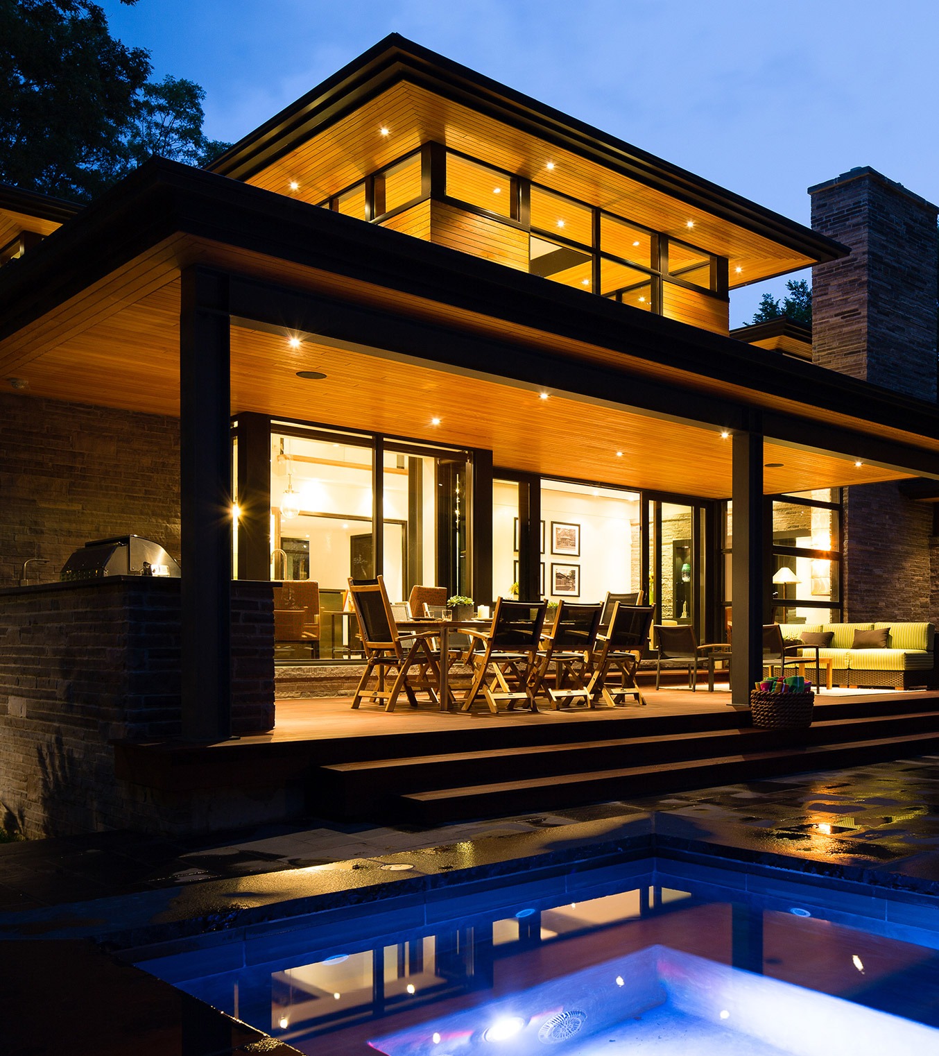 Natural modern home with wood soffit, natural stone and covered deck.