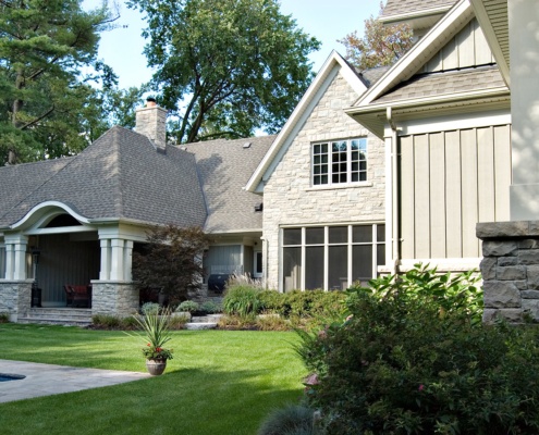 Mississauga home with stone skirt, stone chimney and white trim.