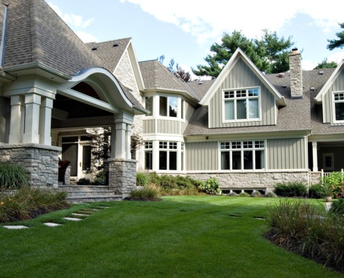 Traditional home with natural stone, wood siding and white frame windows.