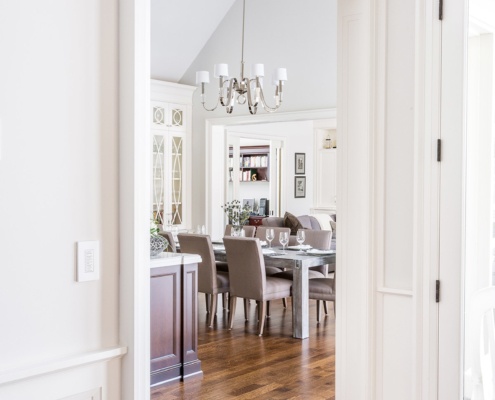 Dining room with wood dining table, gray chairs and hardwood floor.