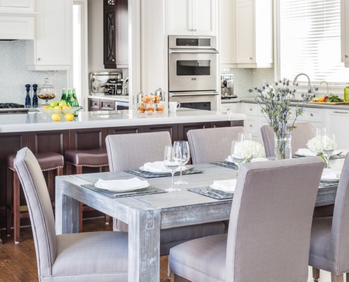 Open concept kitchen with breakfast bar, rustic dining table and hardwood floor.