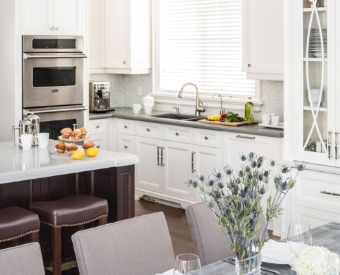 Kitchen with wood island, gray countertop and double oven.