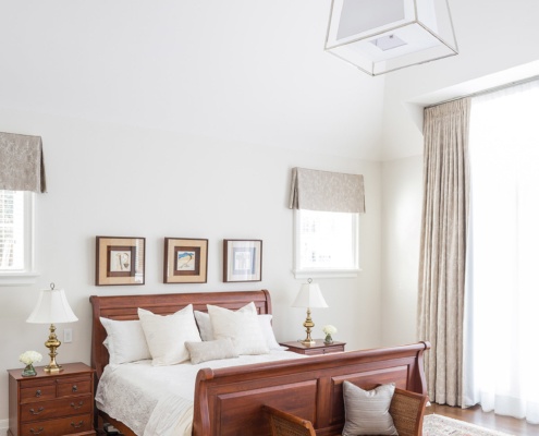 Master bedroom with hardwood floor, vaulted to ceiling and white trim.