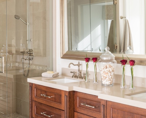 Master bathroom with wood vanity, tile floor and tile shower.