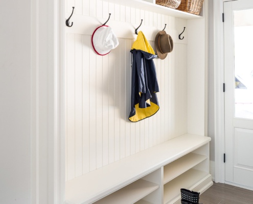 Mud room with white cubby, tile floor and the white door.