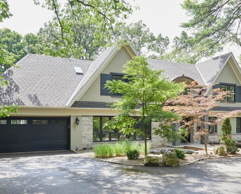 Home renovation with covered front entry, wood front door and arched window.