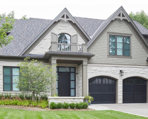 Oakville house with green siding, shutters and arched window.