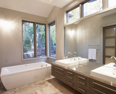 Master bathroom with corner windows, floating vanity and white baseboard.