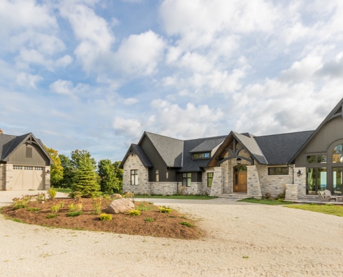 Craftsman style house with two car garage and natural stone.