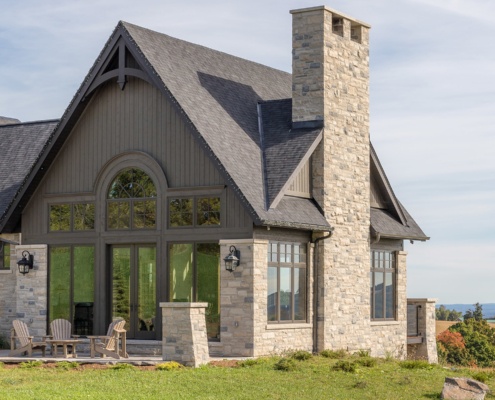 Traditional house with dark wood, dark frame windows and natural stone.