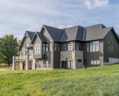 Traditional house with wood siding, natural stone and gabled roof.