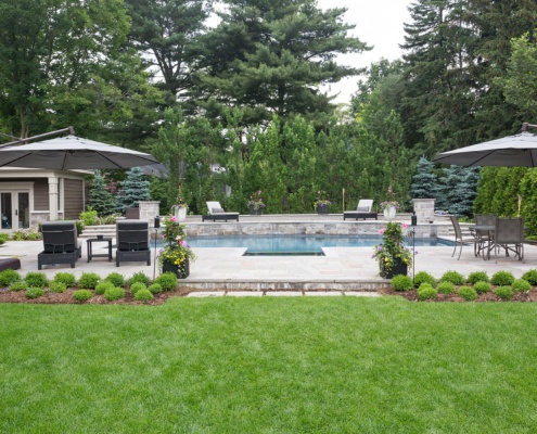 Outdoor living with inground pool, dining table and flagstone.