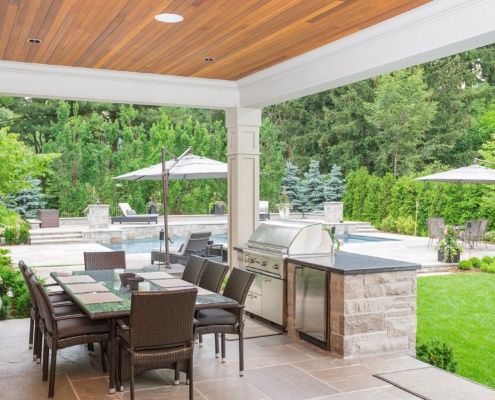 Outdoor deck with stone patio, granite countertop and wood ceiling.