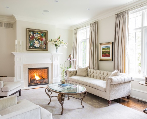 Living room wtih stone fireplace, crown moulding and hardwood floor.