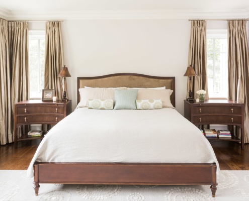 Master bedroom with white baseboard, wood floor and crown moulding.