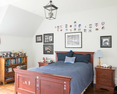 Kids bathroom with hardwood floor, white baseboard and wood furniture.