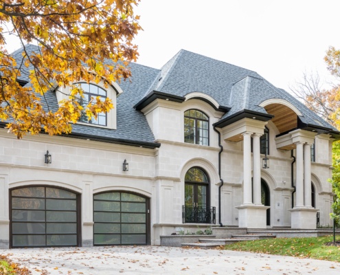 Traditional home with stone columns, cut stone and wood soffit.