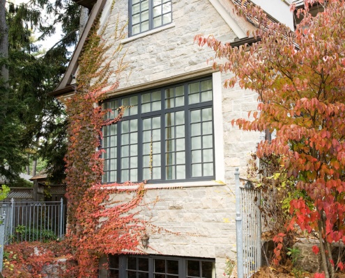 Mississauga house with stone siding, grid windows and wood soffit.